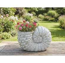 Pflanzgefäss in Form einer Schnecke mit blühenden Blumen auf einem Holztisch im Garten