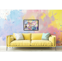 Gelbes Sofa mit Kissen vor einer Wand mit einem gerahmten Bild eines Mädchens und einem Herz