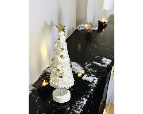 Sapin de Noël décoratif blanc en textile avec étoiles dorées et éclairage LED sur une surface en marbre noir.