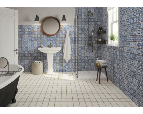 Badezimmer mit Dusche, Waschtisch, Badewanne und blau-weiss gemusterten Fliesen.