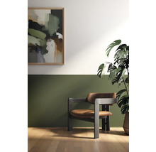 Raumansicht mit Kunstwerk, Sessel, Zimmerpflanze und Wandpaneelen