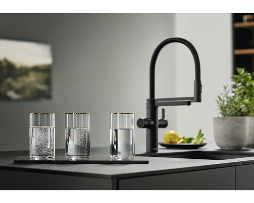 Trois verres d'eau à côté d'un robinet de cuisine noir sur un comptoir de cuisine.