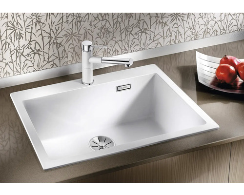 Weisse Küchenspüle mit Armatur auf einer Arbeitsplatte