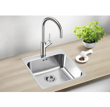 Évier avec robinet, pot d'herbes et mortier sur un plan de travail