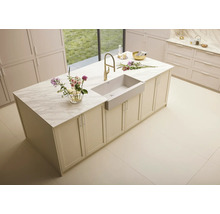 Kücheninsel mit Spüle, Armatur und Marmorplatte in einem hellen Raum