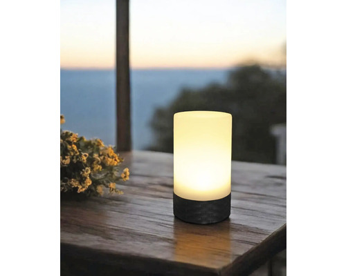 Leuchtende Tischleuchte auf Holztisch mit Blick auf die Landschaft