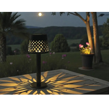 Dekorative Tischleuchte im Aussenbereich mit Lichteffekten auf einem Gartentisch