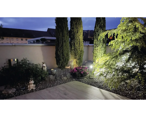 Gestalteter Garten mit Pflanzen, Gartenfiguren und Beleuchtung