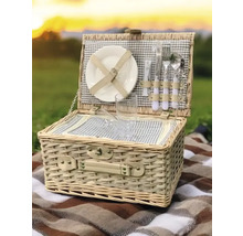 Panier de pique-nique ouvert avec vaisselle sur une couverture à l'extérieur