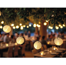 Dekorative Lichterkette mit runden Lampen im Aussenbereich über Tischen