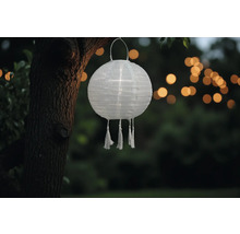 Lanterne en papier avec pompons dans le jardin.