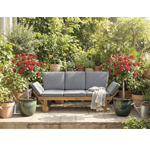 Mobilier de jardin avec roues, coussins, couverture, rosier en pot et diverses plantes dans le jardin.