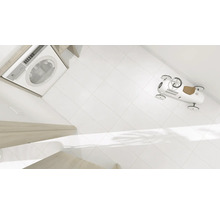 Waschmaschine, weisse Fliesen und ein Spielzeugauto im Badezimmer