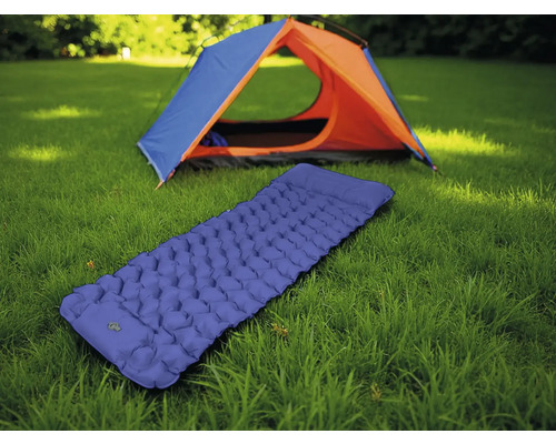 Aufblasbare blaue Isomatte vor einem Zelt auf einer Wiese.
