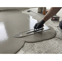 Verarbeiten von Ausgleichsmasse mit einer Glättkelle auf einem Boden