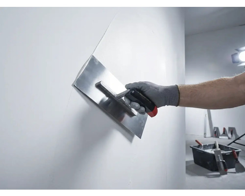 Hand mit Putzglätter beim Glätten einer Wand