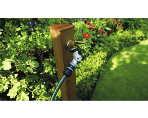 Gartenszene mit Wasserhahn, Gartenschlauch und Verbinder