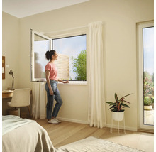 Chambre lumineuse avec fenêtre oscillo-battante et une femme regardant dehors