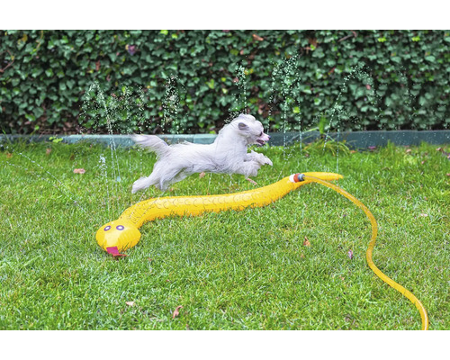 Chien sautant par-dessus un arroseur de jardin en forme de serpent