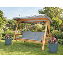 Balancelle en bois avec coussins gris et toit dans le jardin