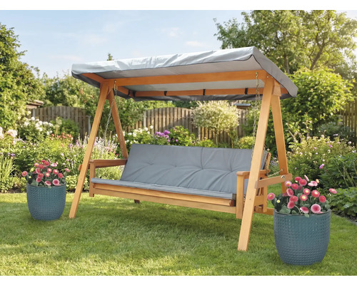 Balancelle en bois avec coussins gris et toit dans le jardin
