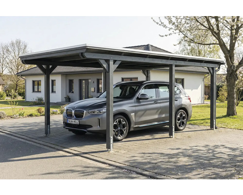 Voiture grise sous un abri de voiture devant une maison