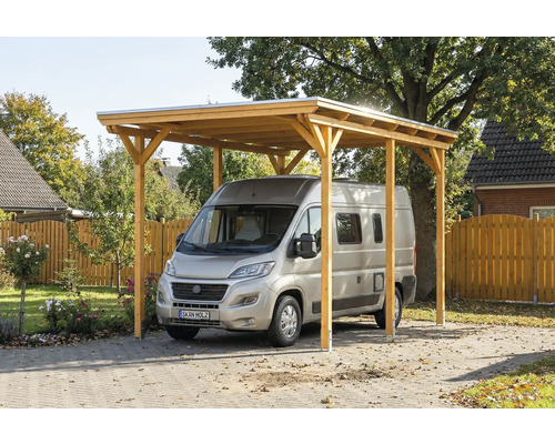 Carport aus Holz mit silbernem Auto auf einem gepflasterten Hof.