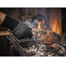 Gant de barbecue avec viande sur le grill