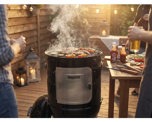 Barbecue fumoir avec viande et légumes sur la grille lors d'une fête barbecue dans le jardin.