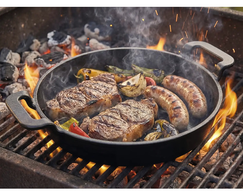 Poêle à griller avec steaks, saucisses et légumes sur le gril
