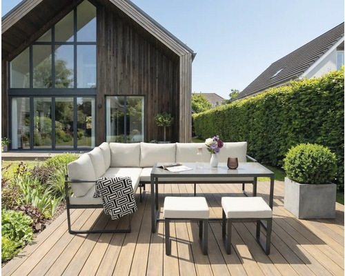 Ensemble de salon de jardin avec table et tabourets sur une terrasse en bois devant une maison