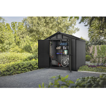 Abri de jardin avec porte ouverte, équipé d'étagères, d'une tondeuse à gazon et d'un vélo