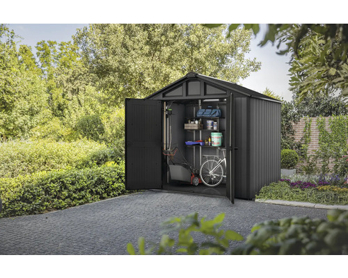 Abri de jardin avec porte ouverte, équipé d'étagères, d'une tondeuse à gazon et d'un vélo