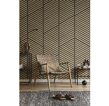 Mur avec panneaux de lattes en bois géométriques dans un salon avec un fauteuil en cuir tressé et un tapis gris.