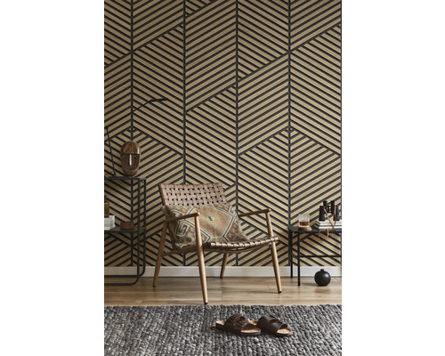 Mur avec panneaux de lattes en bois géométriques dans un salon avec un fauteuil en cuir tressé et un tapis gris.