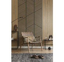 Panneau mural avec motif géométrique à lattes aspect bois derrière un fauteuil dans un salon moderne avec sol en bois.