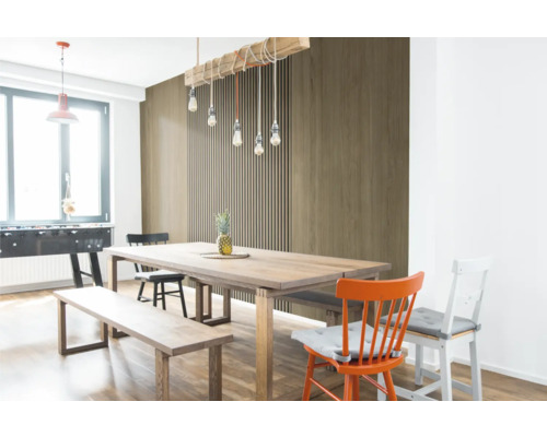 Coin repas lumineux avec table en bois et panneaux muraux aspect bois, composés de lamelles et d'éléments de décor bois lisses.