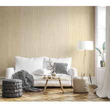 Salon moderne avec papier peint effet bois clair à lamelles, canapé blanc, table basse ronde et parquet en chevrons.