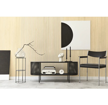 Espace de vie moderne avec revêtement mural en bois clair et structure à lattes. Buffet en métal noir, fauteuil et décoration sobre.