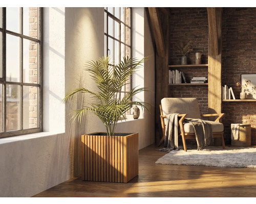 Bac à plantes carré en lattes de bois avec une plante d'intérieur dans un salon lumineux avec mur en briques et grandes fenêtres.