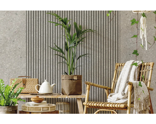 Espace de vie moderne avec panneaux acoustiques, mur aspect pierre, plantes d'intérieur et fauteuil en rotin.
