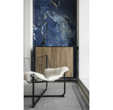 Intérieur avec revêtement mural en marbre bleu, buffet en bois à cadre noir et chaise en fil d'acier avec peau de mouton sur un tapis gris.
