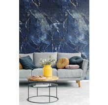 Papier peint intissé avec motif marbre bleu foncé et veines claires dans un salon moderne avec canapé gris et table basse.