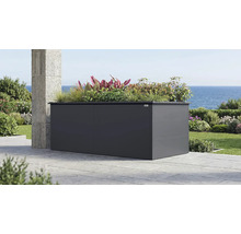 Grand bac à fleurs surélevé Weka en métal anthracite sur une terrasse avec vue sur la mer, planté de graminées et de plantes diverses.