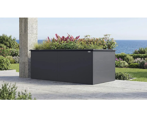 Grand bac à fleurs surélevé Weka en métal anthracite sur une terrasse avec vue sur la mer, planté de graminées et de plantes diverses.