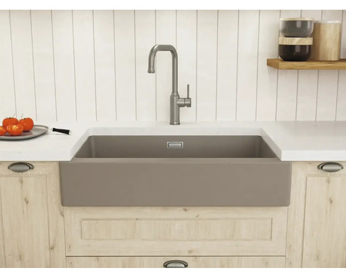 Moderne Landhausküche mit einem taupefarbenen Spülstein, einer hohen Mischbatterie aus gebürstetem Metall und hellen Holzunterschränken.