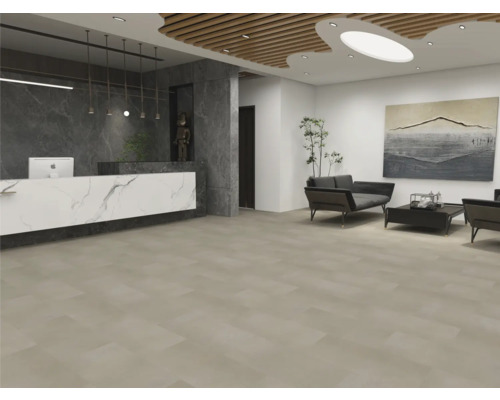 Espace de réception moderne avec de grands carreaux de sol beiges, un comptoir aspect marbre et un coin salon avec des canapés sombres.