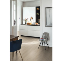 Pièce moderne et lumineuse avec un sol stratifié aspect bois clair, un îlot de cuisine blanc avec plan de travail noir et des chaises design.