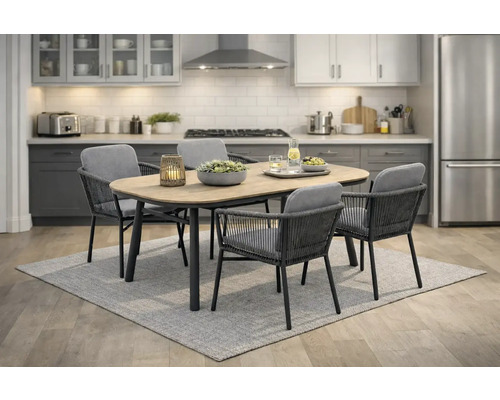 Modernes Essgruppenset bestehend aus ovalem Esstisch mit Holzoptik-Platte und vier geflochtenen Sesseln mit grauen Polstern in einer hellen Küche.