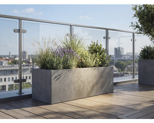 Rechteckiger Pflanzkübel in Betonoptik auf einer Dachterrasse mit Holzdielen und Glasgeländer, bepflanzt mit Lavendel und Gräsern.